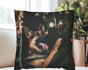 May include: A decorative throw pillow featuring a German Shepherd dog with its tongue out, interacting with a Christmas tree adorned with ornaments. The dog is wearing a red collar. The pillow is on a white couch.