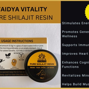May include: A round black tin of Vaidya Vitality Pure Shilajit Resin with a yellow label, accompanied by a rectangular instruction card. The label displays the text Organic, Vegan, Potent, Lab Tested, and 20g. The card lists usage instructions.
