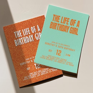 Può includere: Due inviti di compleanno rettangolari. Uno è arancione con testo bianco: "THE LIFE OF A BIRTHDAY GIRL". L'altro è verde acqua con lo stesso testo arancione. Dettagli: data, ora e luogo.