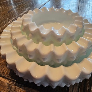 Three nesting Fenton hobnail milk glass ashtrays