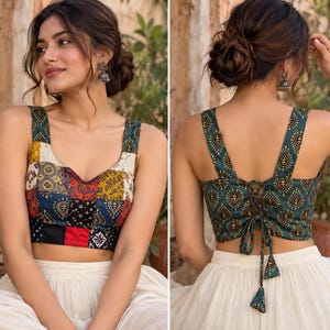 May include: A sleeveless crop top featuring a patchwork front with various colorful patterns and a solid dark green back with a repeating teardrop motif. The back includes a lace-up closure with fabric ties and dangling tassels at the ends.