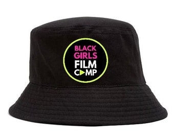 May include: Black bucket hat with a yellow circle and the text "Black Girls Film Camp" in pink and white letters.