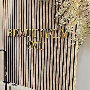 May include: A black and white striped wall with the words "BEAUTIFLY PMU" in gold letters.