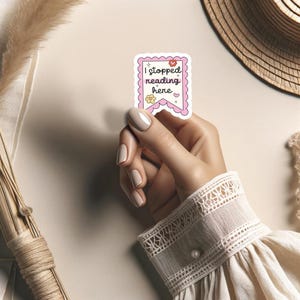 K&ouml;nnte beinhalten: Ein rosa-wei&szlig;er Aufkleber mit dem Text "Ich habe hier mit dem Lesen aufgeh&ouml;rt" in Bannerform mit Herzen und Sternen.