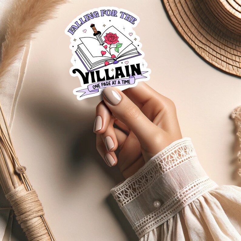 May include: A sticker with a book, a rose, and a dagger. The text reads "Falling for the Villain, One Page at a Time."