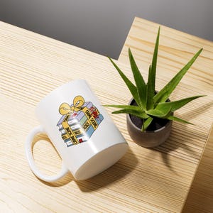 May include: White ceramic mug with a graphic of a stack of books wrapped in yellow ribbon and labeled "Crime Scene Do Not Cross".