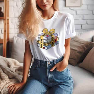 May include: A white t-shirt with a graphic of a stack of books wrapped in yellow crime scene tape with the text "Crime Scene Do Not Cross".