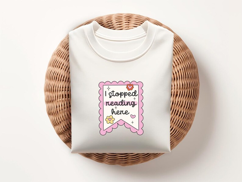 K&ouml;nnte beinhalten: Wei&szlig;es T-Shirt mit einem rosa Banner, auf dem "Ich habe hier mit dem Lesen aufgeh&ouml;rt" steht, mit einem Blumen- und Sternendesign.