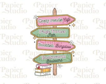 Op de afbeelding: Een houten wegwijzer met vier richtingspijlen die naar verschillende boekenthema's wijzen: Cozy Reads Cafe, Page Turner Path, Bookish Bungalow en Bookworm Boulevard. De wegwijzer is versierd met bloemen en een stapel boeken.