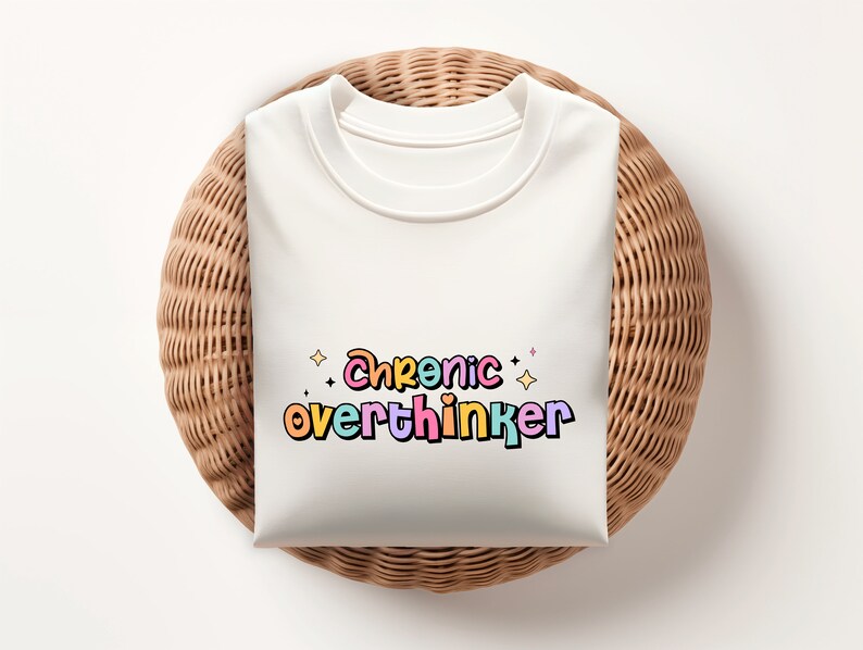 May include: White t-shirt with the text "Chronic overthinker" in colorful, outlined letters with stars.