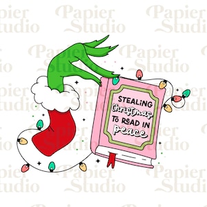 Puede incluir: Una mano verde con un calcetín de Santa Claus rojo sostiene un libro rosa con el texto "STEALING Christmas TO READ IN peace". La mano está rodeada de una cadena de luces navideñas de colores.