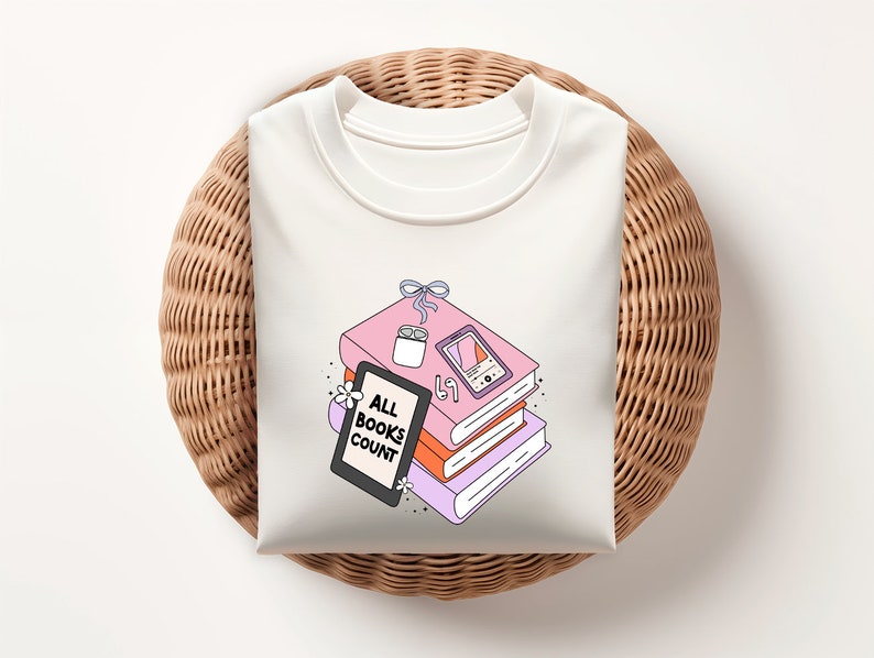 May include: White t-shirt with a graphic of a stack of books, a candle, a phone, and the text "ALL BOOKS COUNT".