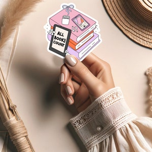 May include: A sticker featuring a stack of books, an e-reader, and a pair of earbuds. The e-reader has the text "ALL BOOKS COUNT" on the screen. The sticker is pink, purple, and orange.