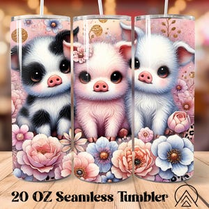 May include: A 20 oz seamless tumbler featuring three adorable cartoon pigs in black and white, pink, and white. The pigs are surrounded by pink, blue, and white flowers. The tumbler has a pink background with gold accents and the text "20 OZ Seamless Tumbler".