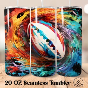 May include: A 20 oz seamless tumbler featuring a colorful abstract design with a rugby ball at the center. The background has swirling patterns in shades of red, orange, blue, and purple. The tumbler has a white straw.