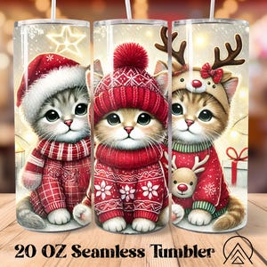 May include: Three 591 ml seamless tumblers showcasing cute cartoon kittens in winter outfits. Each kitten is dressed in a red hat and sweater, with one in a Santa hat, one in a knit cap, and one with reindeer antlers. The tumblers have a winter holiday theme.