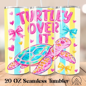 May include: A 20 oz seamless tumbler with a colorful design. The tumbler features a pink sea turtle with a turquoise shell, the words "Turtley Over It" in pink, and pink and blue bows. The background has vertical stripes of yellow, blue, and white.