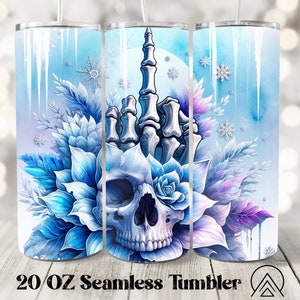 Puede incluir: Un vaso de acero inoxidable de 20 oz con un diseño de invierno. El diseño presenta un patrón floral azul y morado con una calavera y una mano esquelética haciendo el dedo medio. El fondo es azul claro con carámbanos blancos.
