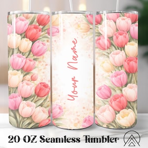 May include: A 20 oz seamless tumbler featuring a watercolor design of pink, red, and yellow tulips. The tumbler has a white background with the text "Your Name" in a cursive font. The bottom of the tumbler has the text "20 OZ Seamless Tumbler".