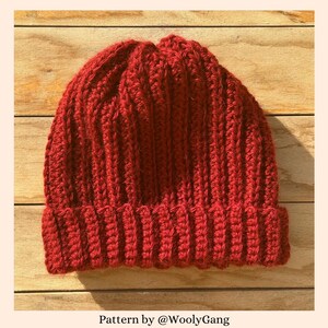 Può includere: Un berretto di lana rosso lavorato a uncinetto con una trama a coste. Modello di @WoollyGang.