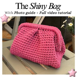 Può includere: Una borsa all'uncinetto rosa lucida fatta a mano con una forma arrotondata, appoggiata su una sedia di legno. La borsa presenta un motivo a punto strutturato e una parte superiore piegata. Il testo sull'immagine recita "The Shiny Bag" e "With Photo guide + Full video tutorial".