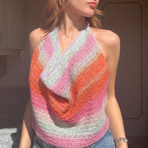 Può includere: Un top a halter in crochet con scollo a scialle. Il top è realizzato con un filato multicolore in tonalità rosa, arancio e verde.