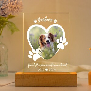 May include: A wooden photo frame with a heart-shaped cutout for a picture. The frame has a white inscription that reads "Barbato" and "You left a paw print on our heart 2013 2024".