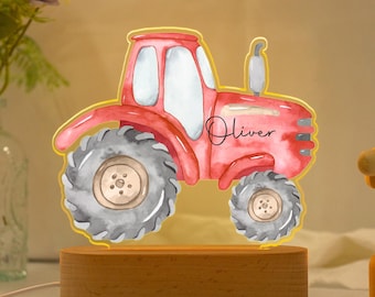 May include: A red tractor night light with a wooden base. The tractor has a gray tire and the name "Oliver" is written on the side.