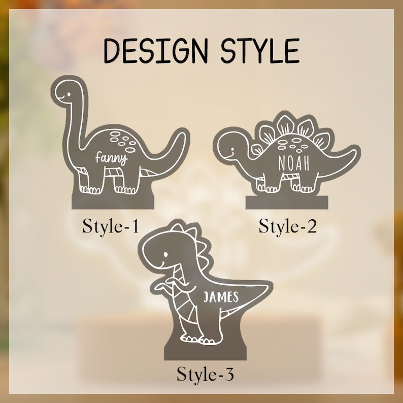 May include: Three grey dinosaur-shaped acrylic stands with white line art and personalised names. The top left is labelled Style-1 with the name Fanny, top right is Style-2 with Noah, and bottom centre is Style-3 with the name James.