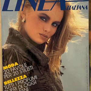May include: Cover of "Linea Italiana" magazine featuring a woman with blonde hair and blue eyes. The magazine title is in large blue letters. Text on the cover includes "Moda," "Bellezza," and other Italian phrases. The background is a light blue.
