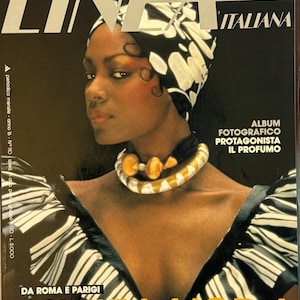 May include: Cover of the Italian fashion magazine, 'Linea Italiana'. The cover features a woman wearing a black and white patterned headscarf and dress. The magazine title is in large silver letters, with the text 'L'ALTA MODA' in yellow.