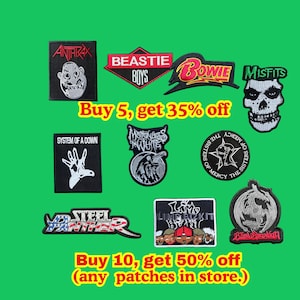 Pode incluir: Uma coleção de emblemas bordados de bandas de música com os logotipos de Anthrax, Beastie Boys, Bowie, Misfits, System of a Down, Motionless in White, The Sisters of Mercy, Steel Panther, Limp Bizkit e Blind Guardian em fundo verde.