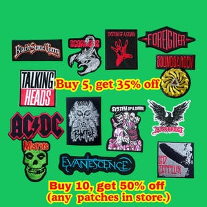 Pode incluir: Uma coleção de patches bordados com logotipos e nomes de bandas, incluindo "AC/DC", "Misfits" e "Led Zeppelin". Os patches são de várias cores e formas, com texto que diz "Buy 5, get 35% off" e "Buy 10, get 50% off".