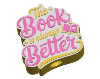 Peut inclure: Une épingle dorée avec le texte "The Book is always Better" en rose et jaune. L'épingle présente une icône de livre et un design en couches avec un fond blanc.
