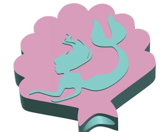 May include: A pink, scalloped-edged emblem featuring a teal mermaid silhouette. The mermaid has long flowing hair and a fishtail. The emblem has a dark teal border and a three-dimensional appearance, set against a white background.