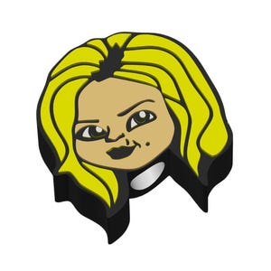 May include: A cartoon-style charm featuring a blonde-haired woman with a stern expression. The charm has a black outline, tan skin, and yellow hair. The woman's lips are black, and she has a beauty mark on her cheek.