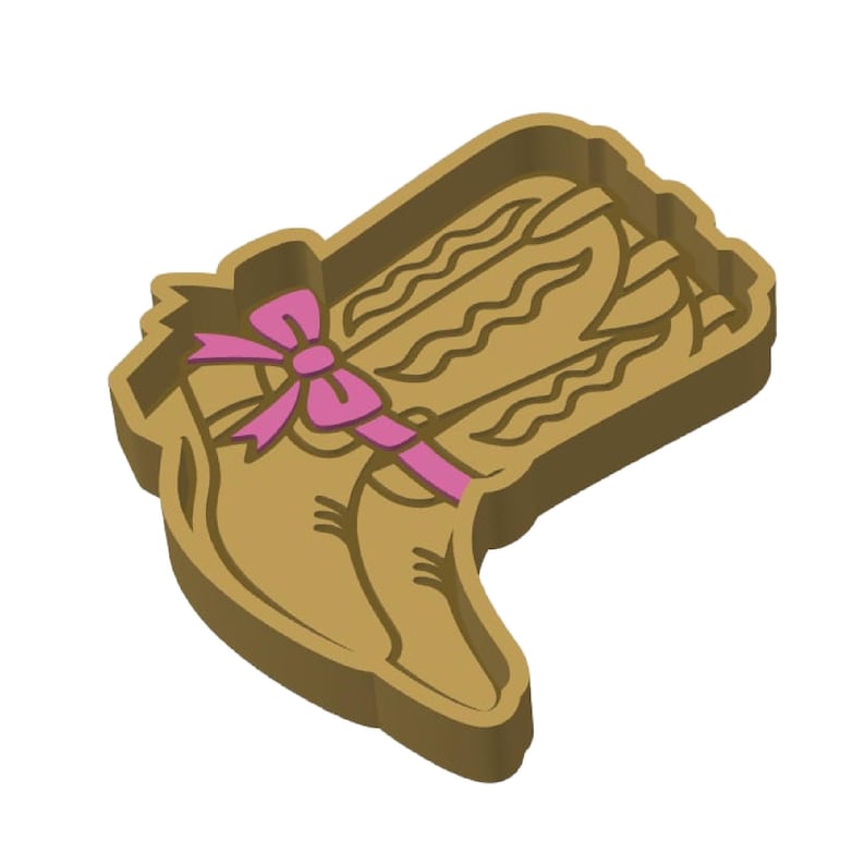 K&ouml;nnte beinhalten: Hellbrauner Ausstecher in Form eines Cowboy-Stiefels mit einer rosa Schleife. Der Stiefel hat detaillierte N&auml;hte und einen geschwungenen oberen Rand, ideal f&uuml;r thematische Kekse.