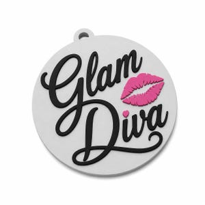 May include: A circular white pendant featuring the black text Glam Diva in a cursive script. A bright pink graphic of lips is positioned to the right of the word Glam, and a small pink heart is located above the letter i in the word Diva.