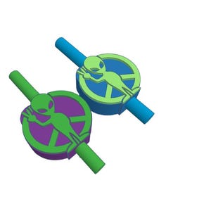 May include: Two green alien figures with peace signs on their chests are attached to colorful plastic straws. The straws are connected to each other.