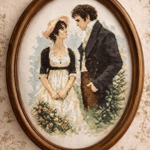May include: An oval-framed cross-stitch embroidery depicting two figures in historical attire standing in a garden. The person on the left wears a white dress with a black bolero and a straw hat, while the person on the right wears a dark coat.