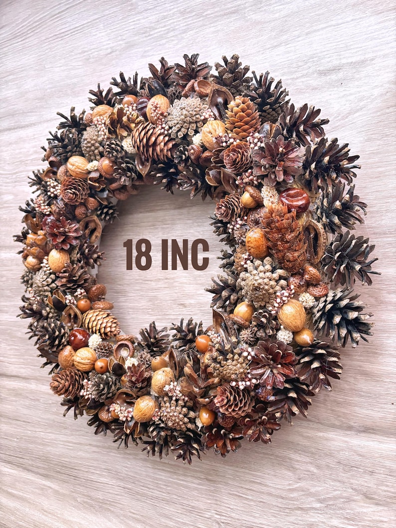 May include: A brown and gold 18 inch pine cone wreath with various natural elements, including acorns, nuts, and berries.