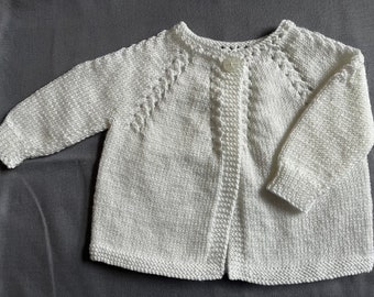 Könnte beinhalten: Ein weißer Strickcardigan mit Knopfleiste und einer zarten Spitzenborte am Ausschnitt und an den Ärmeln.