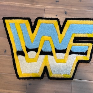 Könnte beinhalten: Ein schwarzer, gelber, weißer und blauer Teppich in Form des Buchstabens "W".