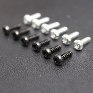 May include: A close-up of a collection of black and silver screws. The screws are arranged in two rows, with the black screws on the left and the silver screws on the right.