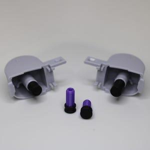 May include: Two gray plastic parts with a black and purple component inside each. There are two additional purple and black components.