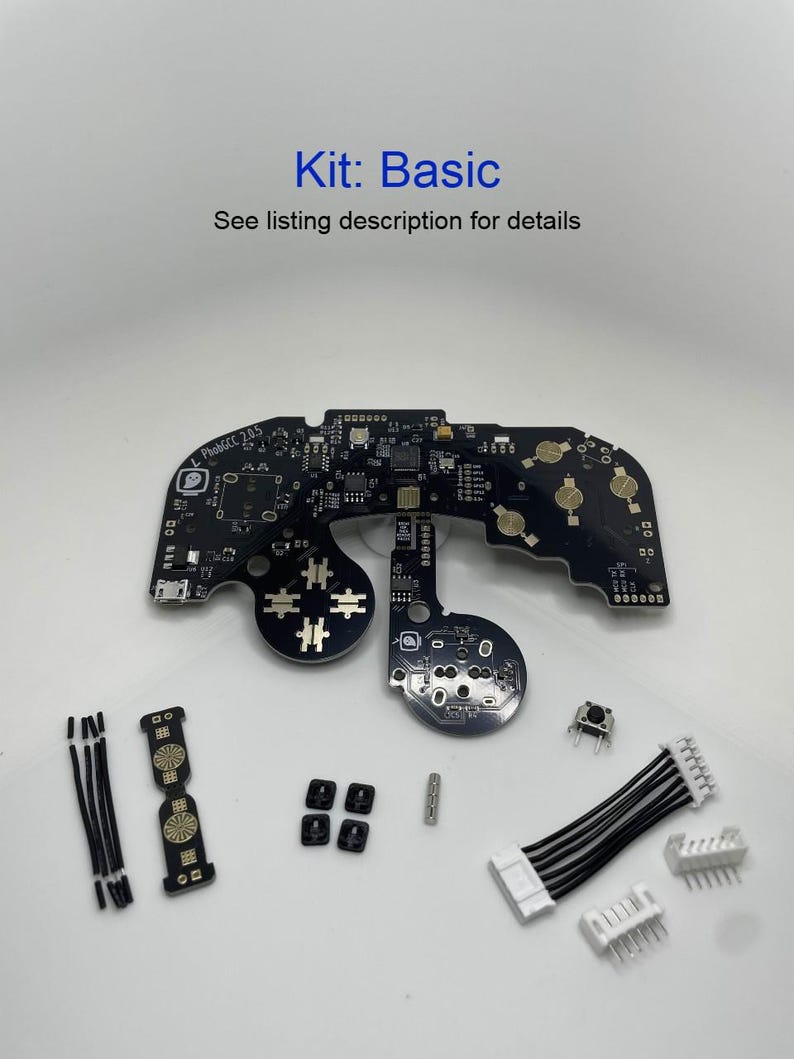 May include: A black circuit board with various components, including buttons, wires, and connectors. The board is labelled "Kit: Basic" and "See listing description for details".