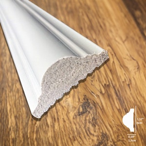 May include: White decorative molding with a scalloped edge. The molding is 1.57 inches wide and 0.59 inches tall.