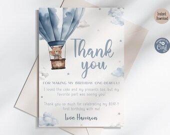 May include: A blue and white thank you card with a watercolor illustration of a teddy bear in a hot air balloon. The card says "Thank you" and "For making my birthday one-derful! I loved the cake and my presents too, but my favorite part was seeing you! Thank you so much for celebrating my bear-y first birthday with me! Love Harrison."