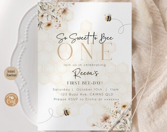 Op de afbeelding: Een beige en gouden uitnodiging met een honingraatpatroon en bloemmotieven. De tekst luidt "So Sweet to Bee One" en "Join us in celebrating Reeva's First Bee-Day!" met details voor het evenement.