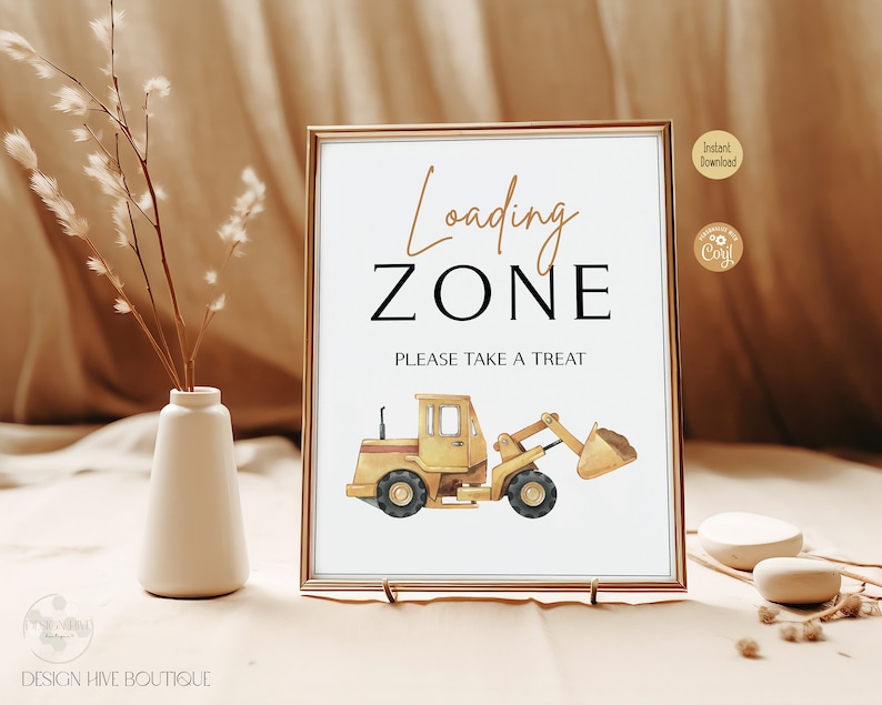 May include: A framed sign with the words "Loading Zone" in a decorative font, and "PLEASE TAKE A TREAT" below. A yellow construction vehicle illustration is at the bottom. The sign is in a gold frame.